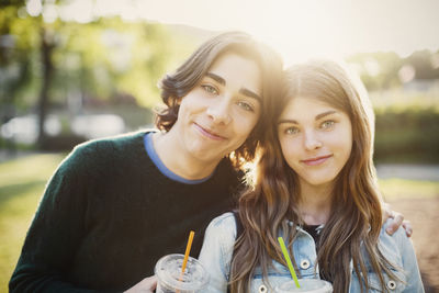 Portrait of smiling teenagers at park on sunny day