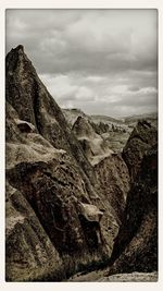 Scenic view of mountains against cloudy sky