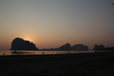 Scenic view of beach against clear sky during sunset