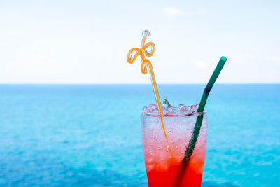 Close-up of drink on glass against sea