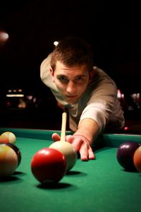 Portrait of young man playing pool