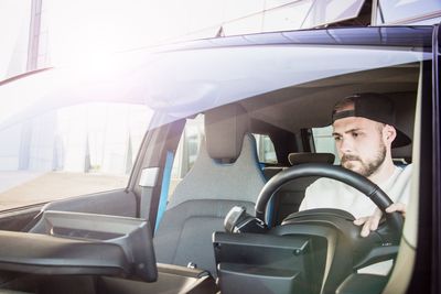 Portrait of young man sitting in car