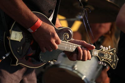 Midsection of man playing guitar