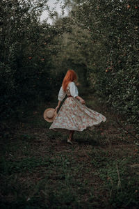 Redhead woman in an apple trees garden