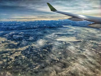 Aerial view of aircraft wing against sky