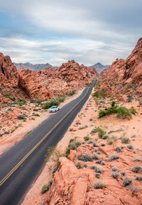 Road leading towards mountains against sky