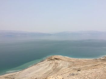 Scenic view of sea and mountains against sky