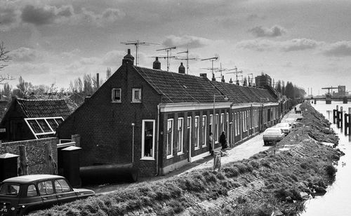 Houses and buildings in town against sky