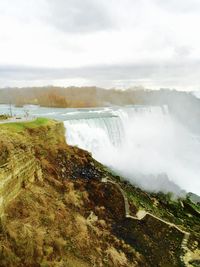 Scenic view of waterfall against sky