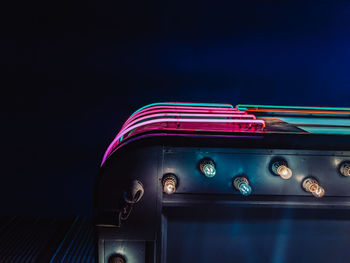 Illuminated car against blue sky at night