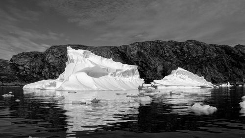 Scenic view of icebergs in river against sky