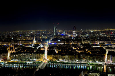 Illuminated cityscape against sky at night