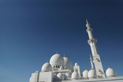 Low angle view of bell tower against clear blue sky