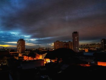 Illuminated buildings against sky at night