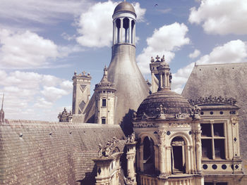 Low angle view of church against cloudy sky during sunny day