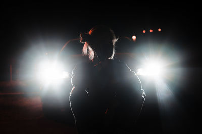 Rear view of woman standing on street at night