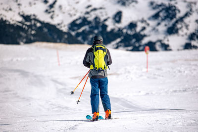 Rear view of person with umbrella on snowcapped mountain