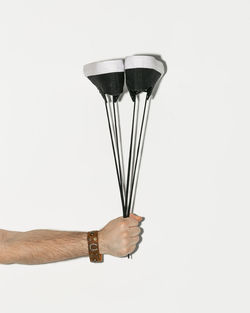 Close-up of hand holding glass against white background