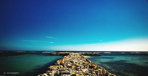 Scenic view of sea against clear blue sky