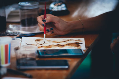 Cropped image of woman painting at table