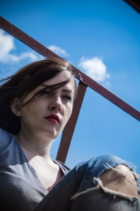 Low section of woman standing against blue sky