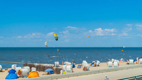 People at beach against blue sky