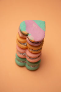 Close-up of multi colored cookies against orange background