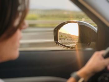 Reflection of man on side-view mirror