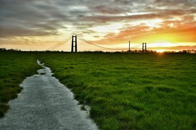 Scenic view of grassy field against cloudy sky