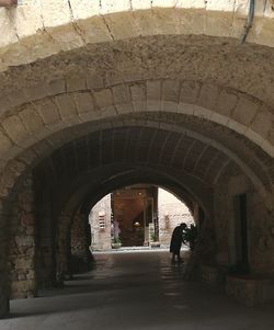 People walking on footpath in tunnel