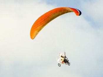 Low angle view of person gliding in sky