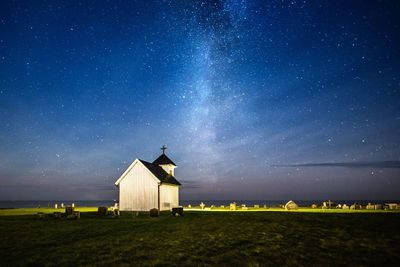 Church on grass against sky at night