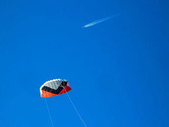 Low angle view of kite flying against clear blue sky