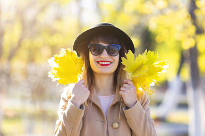 Portrait of young woman with yellow flower