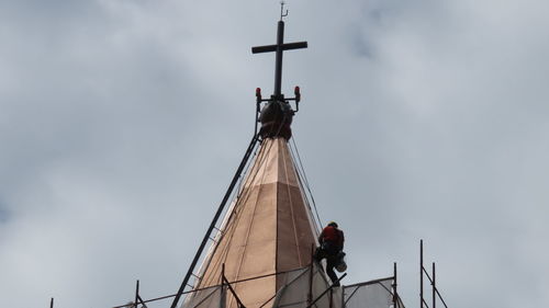 Worker at work on church bell tower