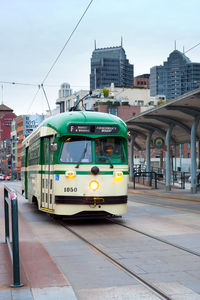 Train on railroad tracks by buildings in city