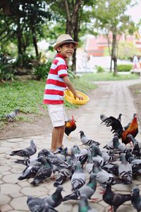 Side view of boy feeding birds
