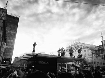 People on street against buildings in city