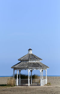 Built structure on beach against clear blue sky