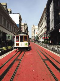 Tram on railroad track amidst buildings in city