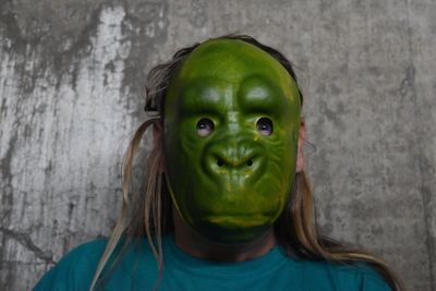 Woman wearing animal mask against the wall