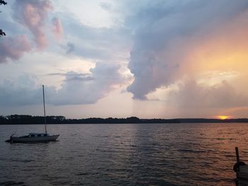Sailboats in sea against sky during sunset
