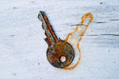 Directly above shot of rusty key and stain on wooden table