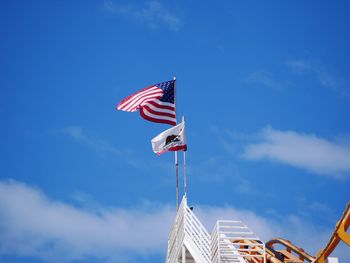 Low angle view of flag against blue sky