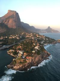 Aerial view of town by sea against sky