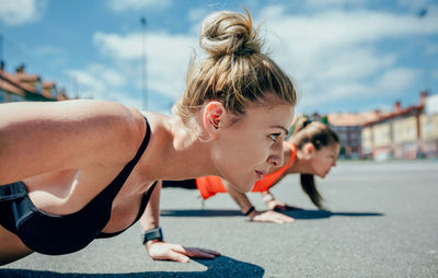 Women doing push-ups on road