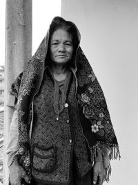 Portrait of woman standing against wall