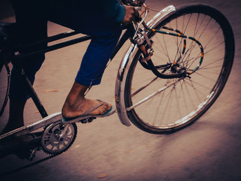 Low section of man riding bicycle on street