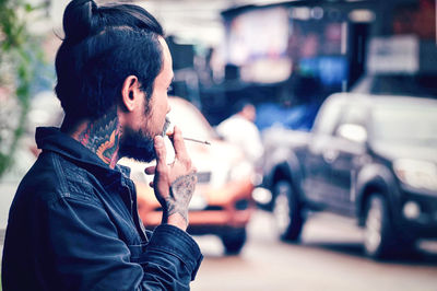 Side view of man smoking cigarette