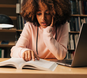 Portrait of woman using laptop at office